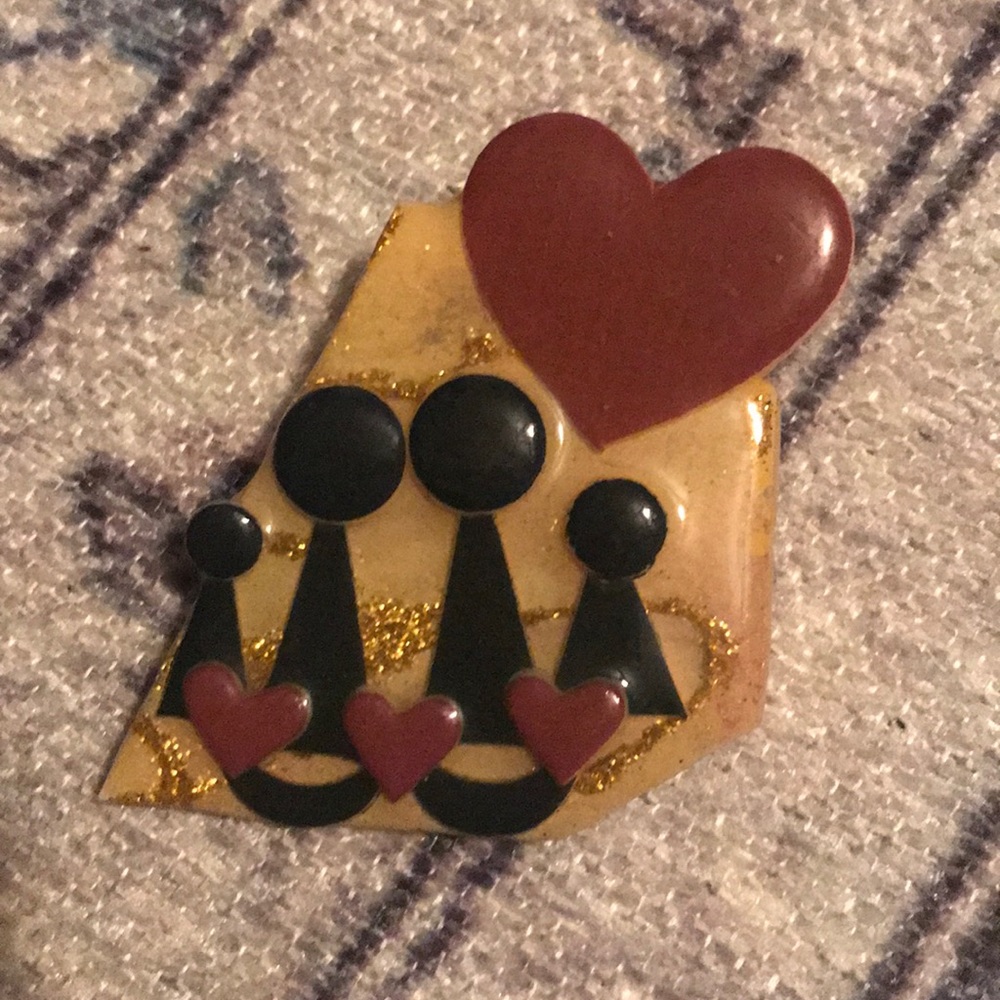 Pin depicting two adult and two children